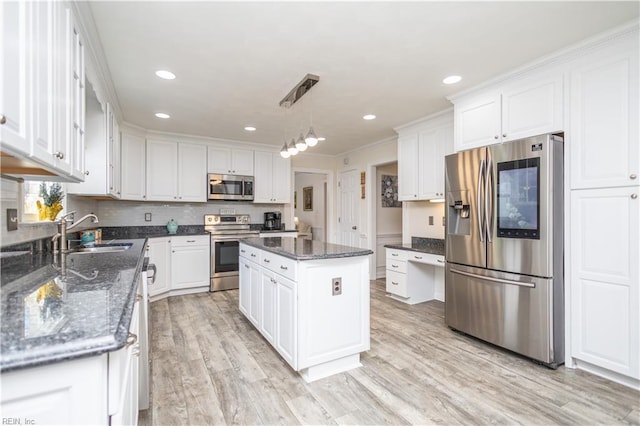 kitchen with a sink, light wood-style floors, stainless steel appliances, and white cabinetry