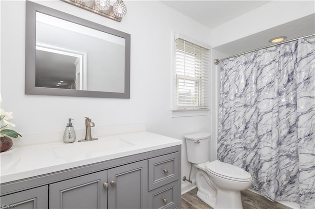 bathroom featuring vanity, toilet, wood finished floors, and a shower with shower curtain