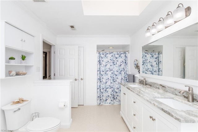 full bathroom featuring double vanity, toilet, ornamental molding, and a sink