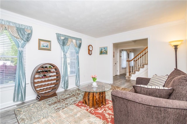living area featuring ornamental molding, wood finished floors, and stairway