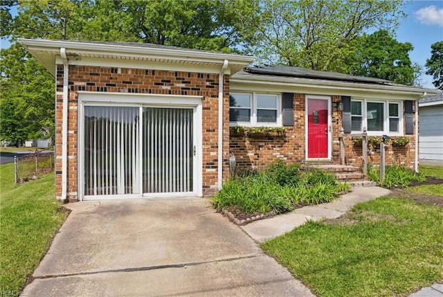 1619 Linden Ave, Chesapeake, VA 23325 - view of front of house featuring roof mounted solar panels, a front yard, and brick siding