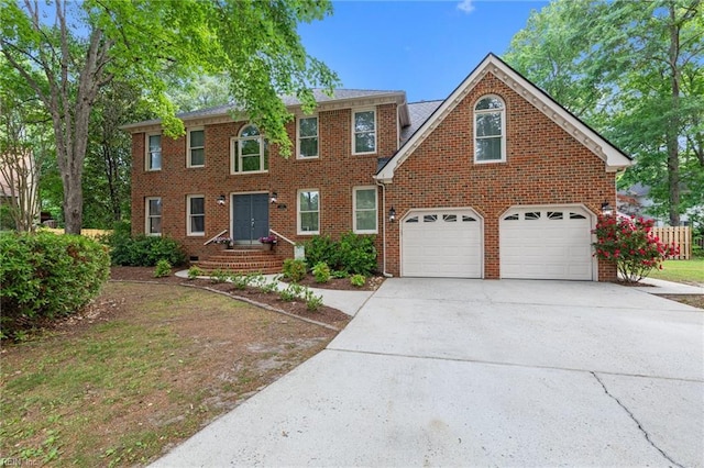 colonial home with brick siding, a garage, and concrete driveway
