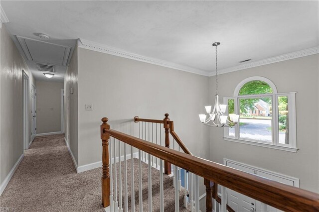 hallway with a notable chandelier, carpet, attic access, an upstairs landing, and visible vents