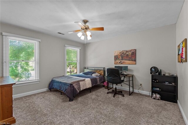 carpeted bedroom with visible vents, baseboards, and ceiling fan