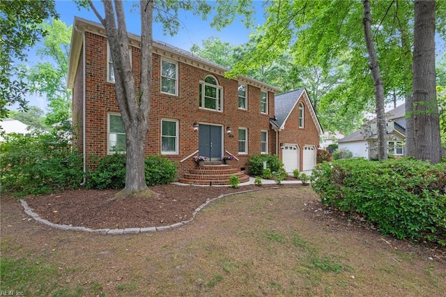 colonial home with brick siding and a garage