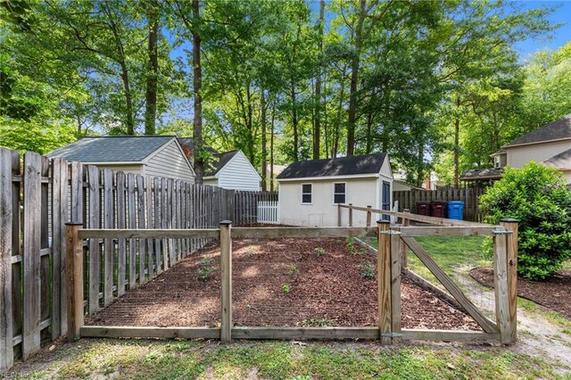view of gate featuring a fenced backyard and an outdoor structure
