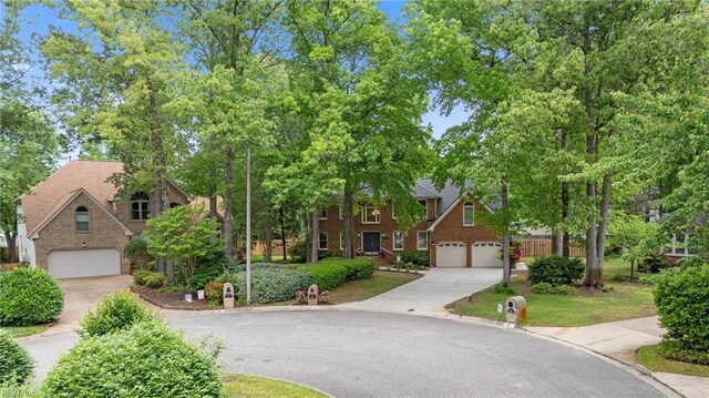 traditional home featuring an attached garage, driveway, and brick siding