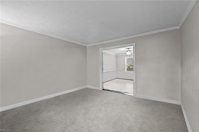 spare room with carpet flooring, a ceiling fan, and ornamental molding