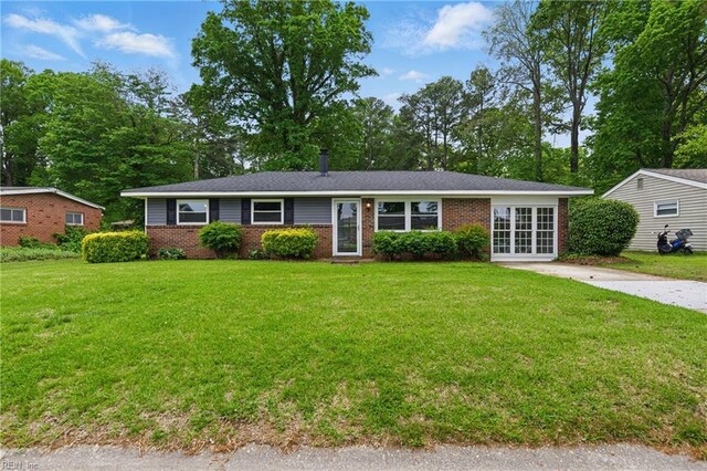 ranch-style home featuring a front lawn, french doors, and brick siding