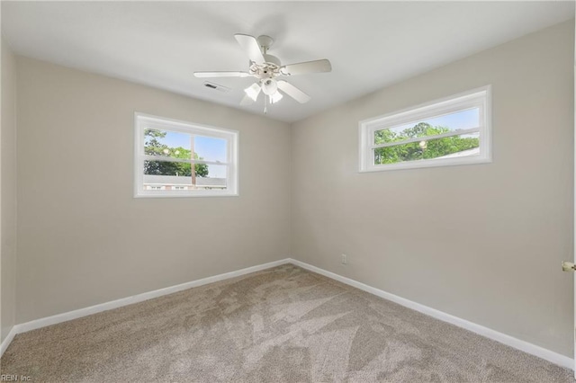 spare room with visible vents, baseboards, carpet floors, and a healthy amount of sunlight