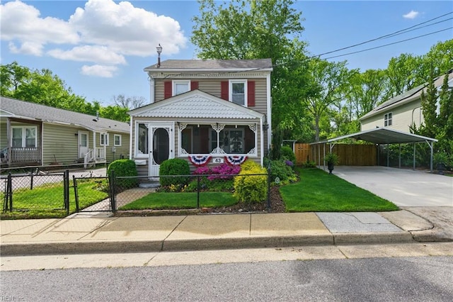 view of front of home featuring a front yard, driveway, a fenced front yard, and a carport