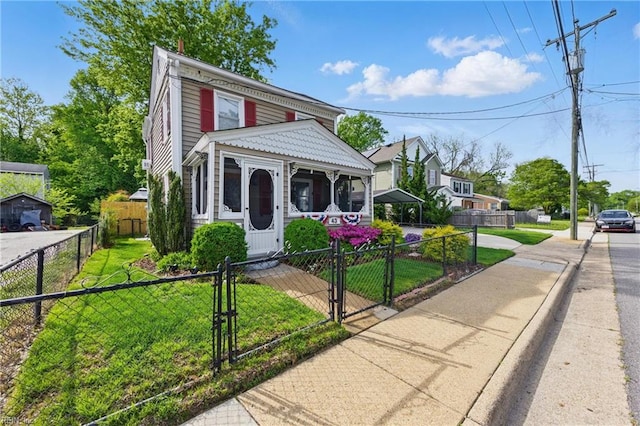 view of front of home featuring a front yard, a fenced front yard, and a gate
