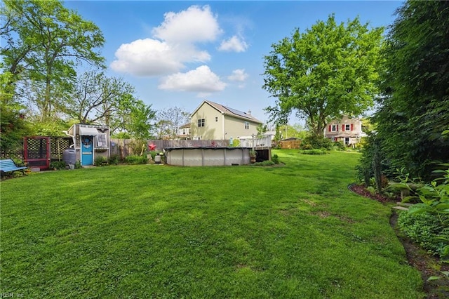 view of yard with a covered pool and fence