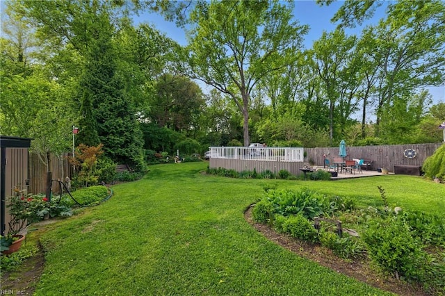 view of yard with a deck, fence, and a patio area
