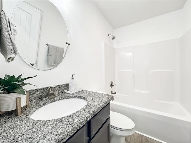 bathroom with wood finished floors, vanity, toilet, and tub / shower combination