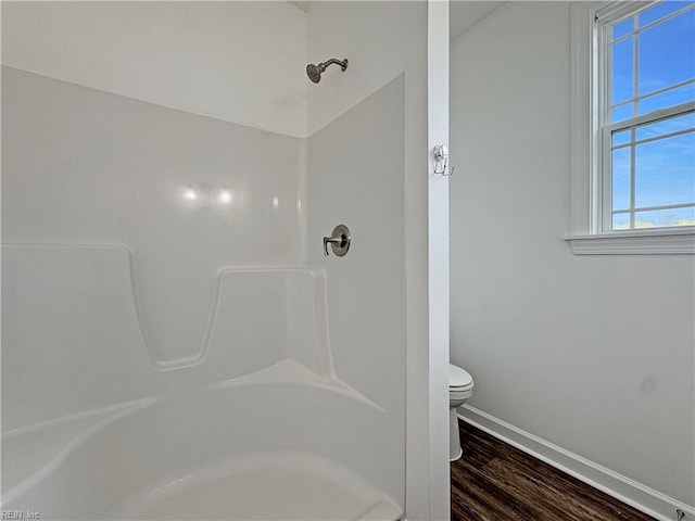 full bathroom featuring wood finished floors, walk in shower, toilet, and baseboards