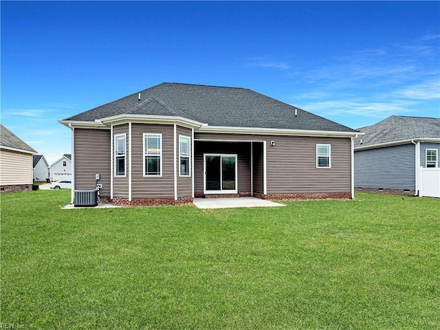 back of property featuring roof with shingles, a patio area, central AC unit, and a lawn