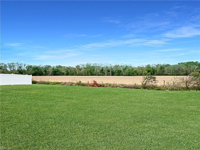 view of yard featuring fence and a rural view