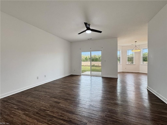 empty room with dark wood-style flooring, ceiling fan, and baseboards