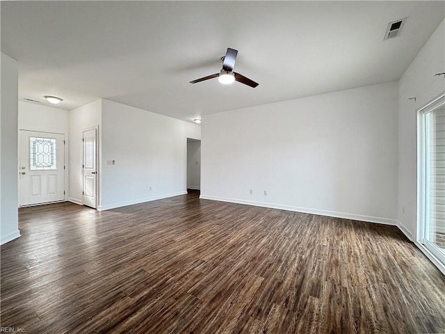 unfurnished living room with a ceiling fan, visible vents, dark wood-style flooring, and plenty of natural light