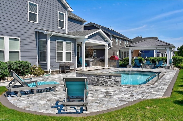 rear view of house with a gazebo, area for grilling, an outdoor pool, and a patio area