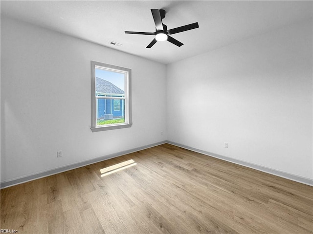 unfurnished room with wood finished floors, ceiling fan, visible vents, and baseboards