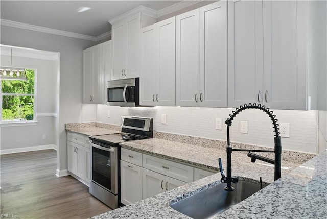1612 Nansemond Pkwy, Suffolk, VA 23434 - kitchen featuring a sink, stainless steel appliances, decorative backsplash, white cabinetry, and baseboards