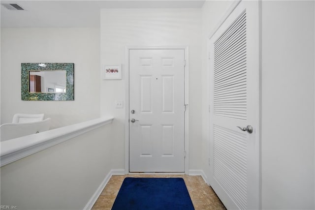 doorway with baseboards and visible vents