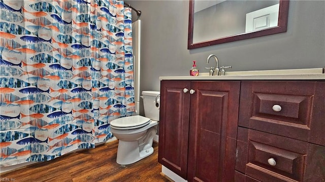 bathroom with wood finished floors, toilet, a shower with shower curtain, and vanity