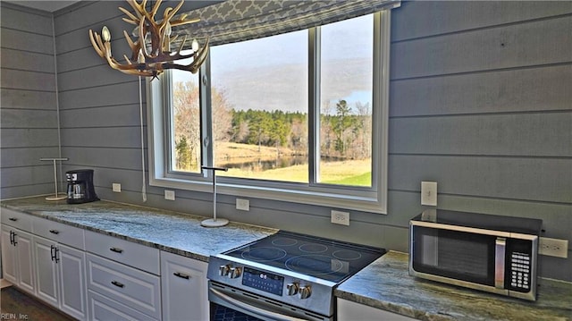 kitchen with appliances with stainless steel finishes, light stone countertops, and white cabinets