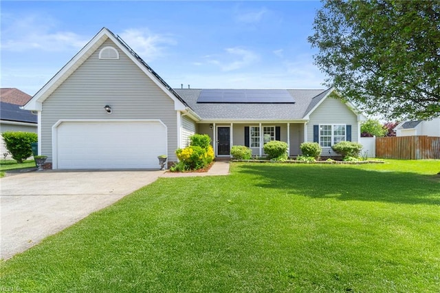 single story home with fence, a front lawn, roof mounted solar panels, and an attached garage
