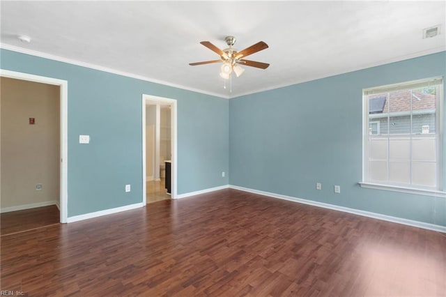 spare room with ceiling fan, visible vents, baseboards, ornamental molding, and wood finished floors