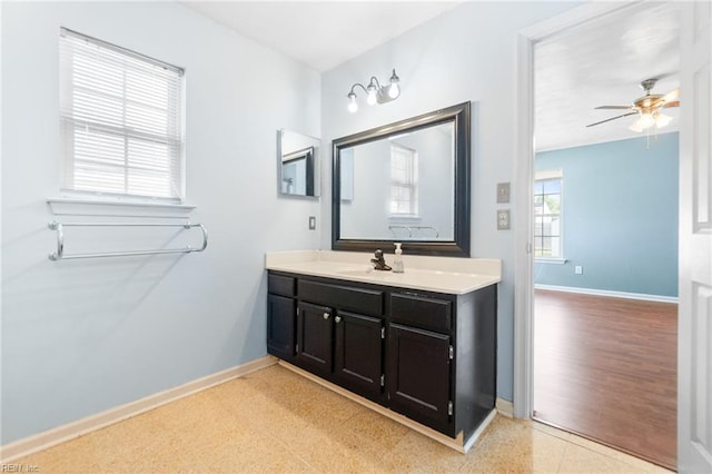 bathroom featuring baseboards, ceiling fan, and vanity