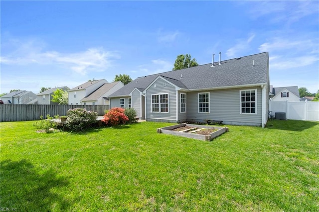 back of house featuring a garden, a yard, a fenced backyard, and central AC unit