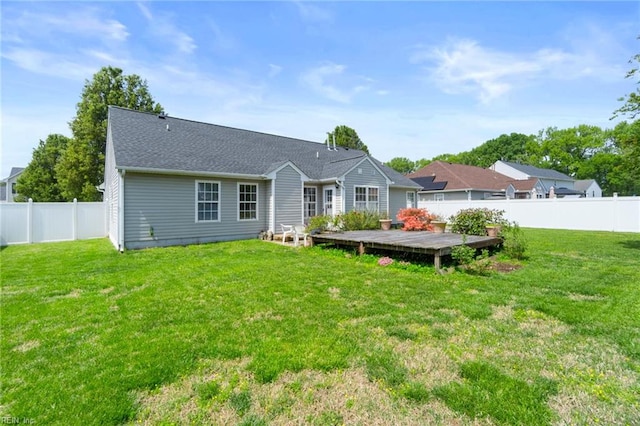 rear view of property with a deck, a yard, and a fenced backyard