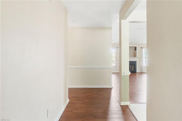 corridor featuring baseboards and wood finished floors