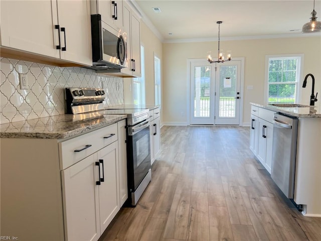 150 Mcpherson Rd, South Mills, NC 27976 - kitchen with light wood finished floors, a sink, a chandelier, stainless steel appliances, and decorative backsplash