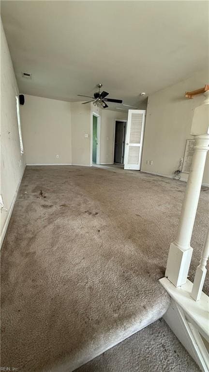 empty room with baseboards, visible vents, ceiling fan, and carpet floors