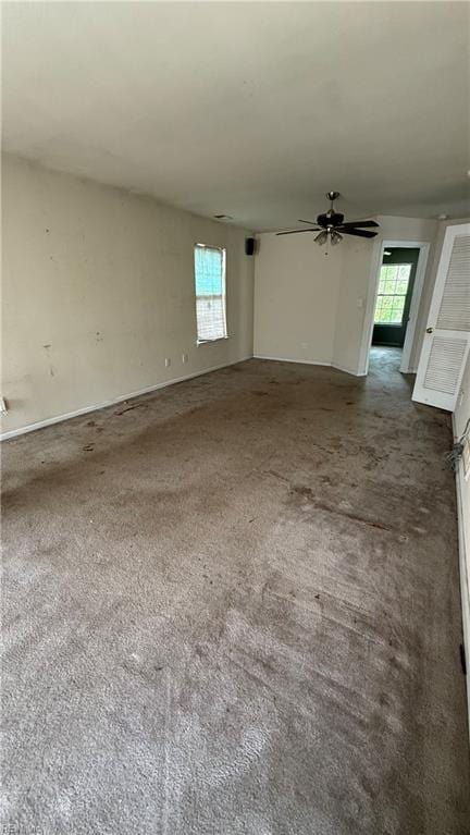 spare room featuring a healthy amount of sunlight, ceiling fan, and carpet floors