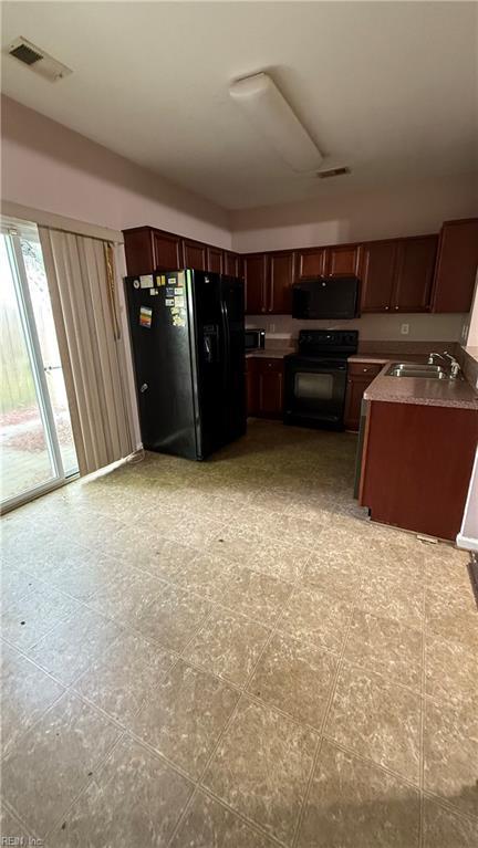 kitchen with visible vents, black appliances, and a sink