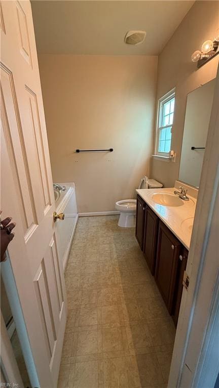 bathroom featuring tile patterned floors, toilet, vanity, baseboards, and a garden tub