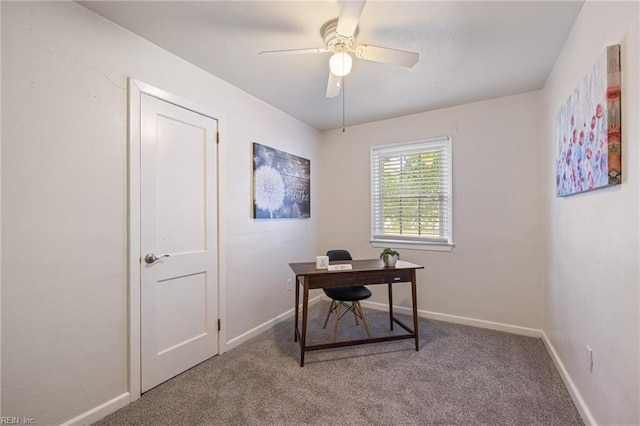 carpeted office with a ceiling fan and baseboards
