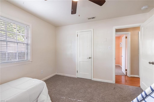 unfurnished bedroom with visible vents, ceiling fan, carpet floors, and baseboards