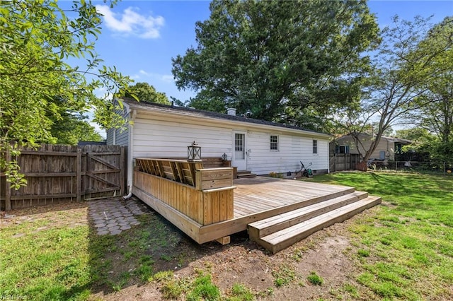back of house with a lawn, a deck, a fenced backyard, and a gate
