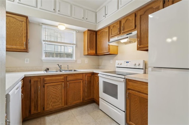 kitchen with white appliances, under cabinet range hood, a sink, and brown cabinetry