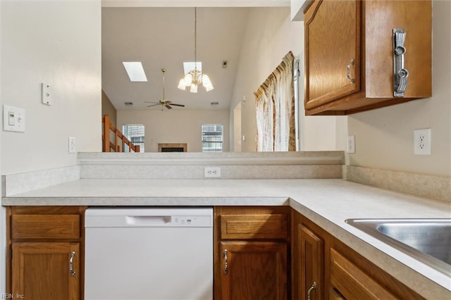 kitchen with dishwasher, brown cabinets, light countertops, and lofted ceiling