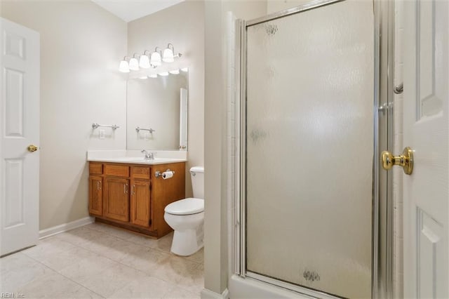 bathroom featuring a stall shower, vanity, toilet, tile patterned flooring, and baseboards