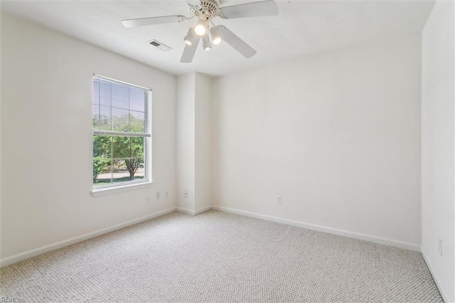carpeted empty room with baseboards and a ceiling fan