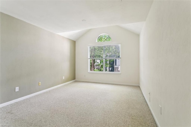 unfurnished room featuring carpet, vaulted ceiling, and baseboards