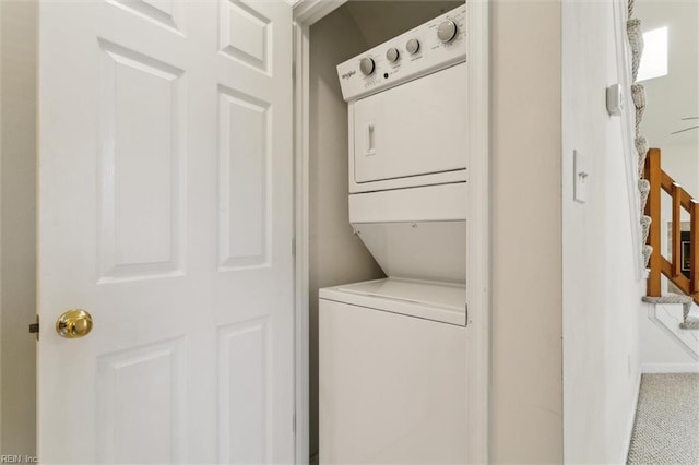 washroom with estacked washer and dryer and baseboards